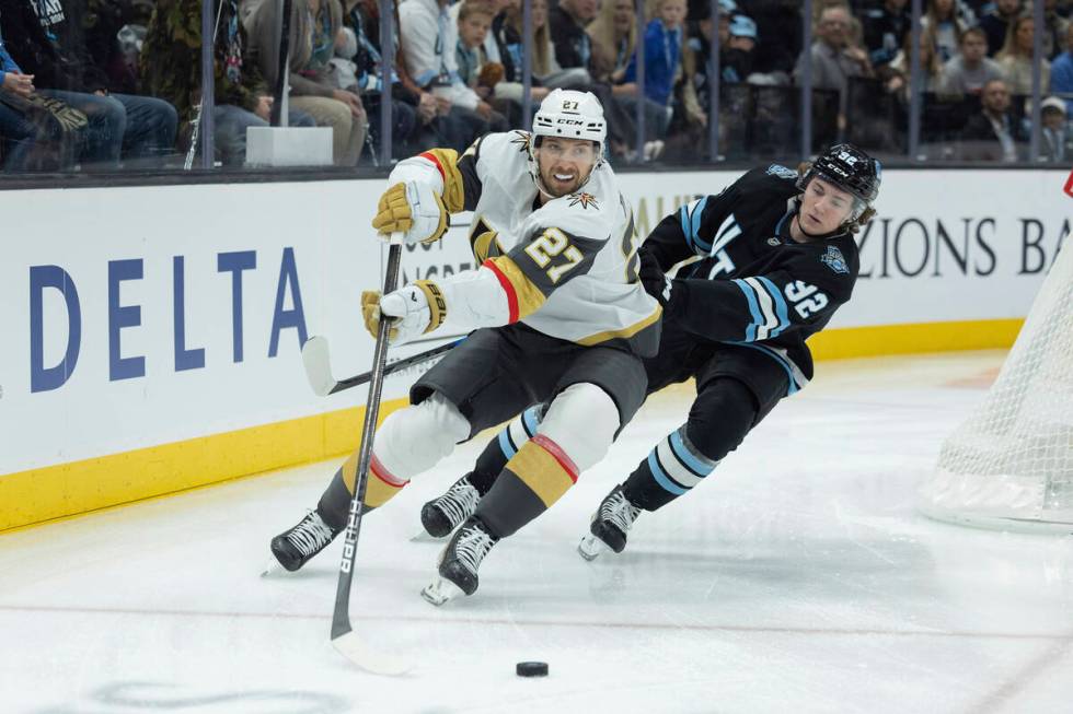 Vegas Golden Knights defenseman Shea Theodore (27) controls the puck against Utah Hockey Club c ...