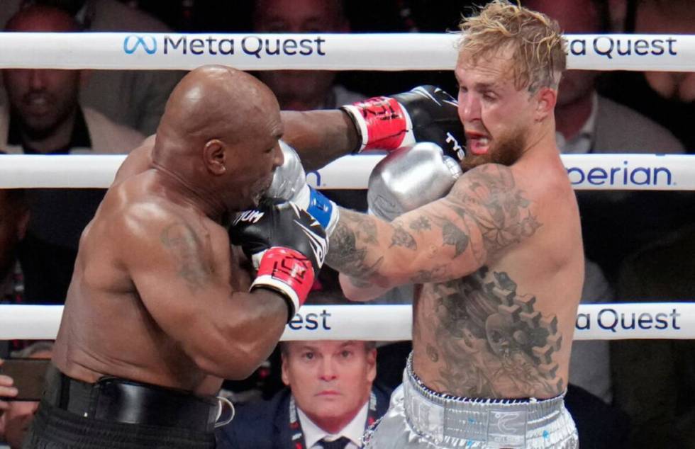 Mike Tyson hits Jake Paul during their heavyweight boxing match, Friday, Nov. 15, 2024, in Arli ...