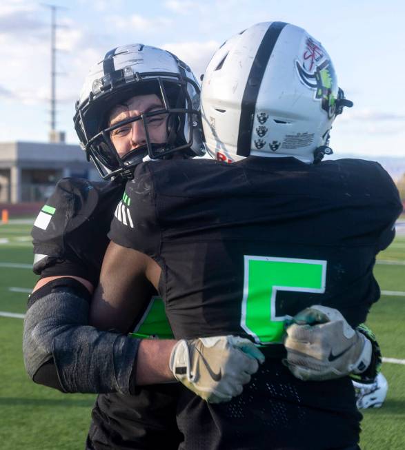 SLAM Academy linebacker Kyler Proudfoot, left, hugs sophomore Dereon Johnson, right, after winn ...