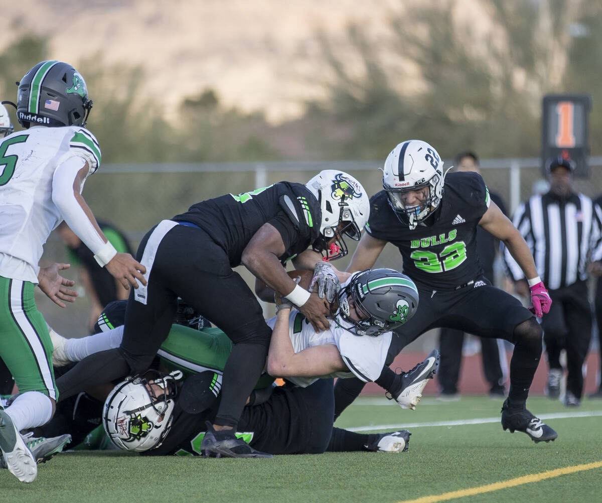 SLAM Academy senior Damien Nevil, left, tackles Churchill County junior Carson Melendy, right, ...