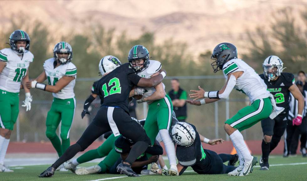 SLAM Academy senior Damien Nevil, left, tackles Churchill County junior Carson Melendy, right, ...