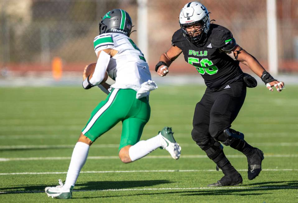 SLAM Academy senior Chenney Chua (56) looks to tackle Churchill County junior Matthew Bird, lef ...