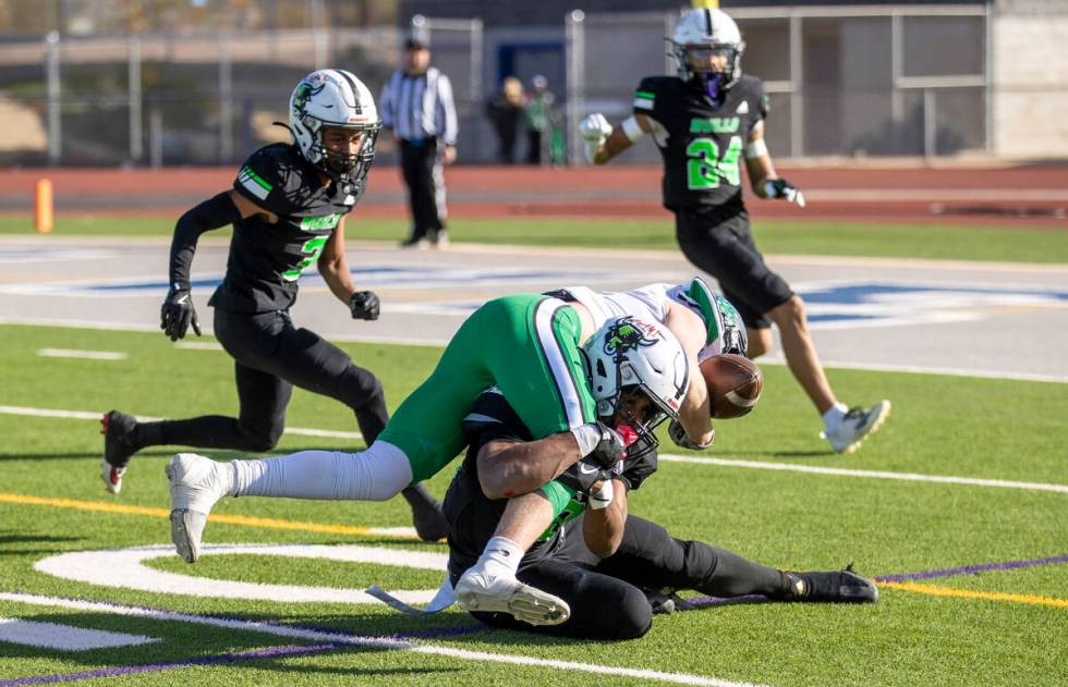 SLAM Academy senior Damien Nevil, bottom, tackles Churchill County junior Carson Melendy, top, ...