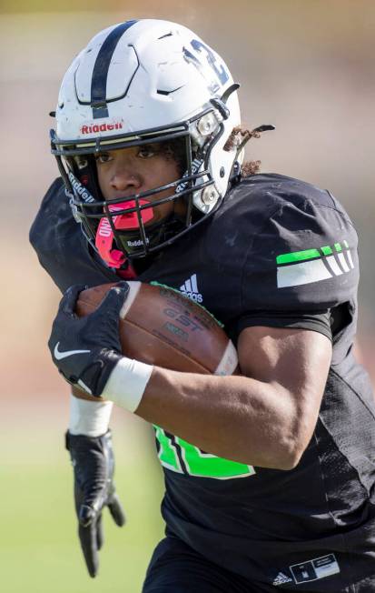 SLAM Academy senior Damien Nevil (12) runs with the ball during the 3A state semifinal football ...