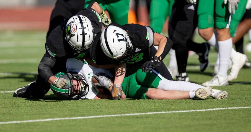 SLAM Academy linebacker Kyler Proudfoot, left, and senior Dylan Tondreau, right, pile on top of ...