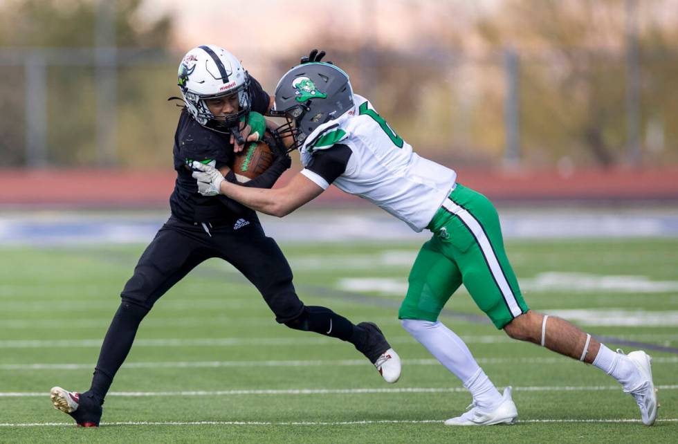 SLAM Academy senior Choy'ce Meloncon, left, is pushed by Churchill County junior Brenan Alves, ...