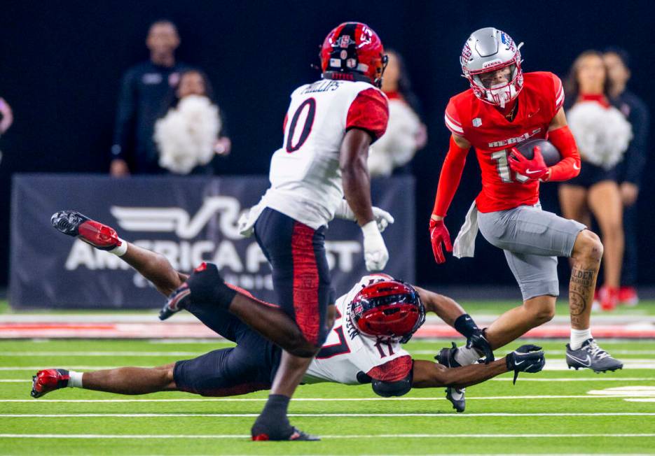 UNLV wide receiver Kayden McGee (16) escapes a tackle on a run by San Diego State Aztecs safety ...