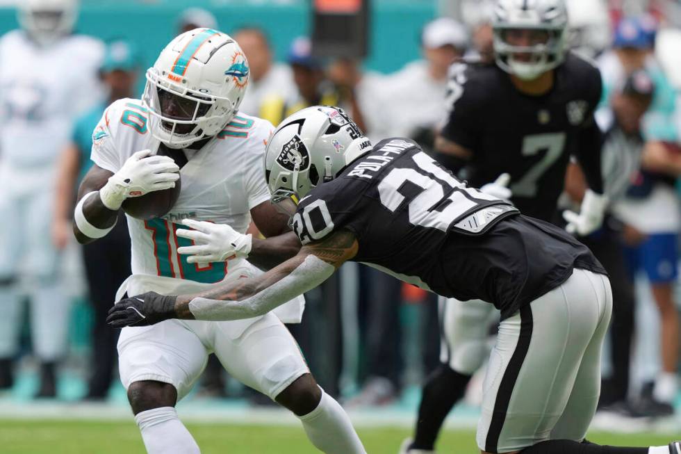 Las Vegas Raiders safety Isaiah Pola-Mao (20) goes after Miami Dolphins wide receiver Tyreek Hi ...