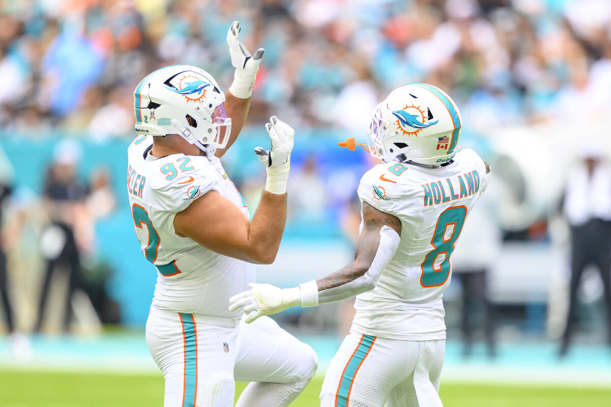 Miami Dolphins defensive tackle Zach Sieler (92) and safety Jevon Holland (8) dance as they cel ...