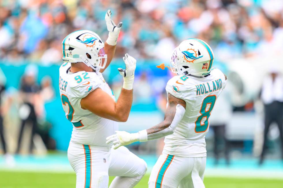 Miami Dolphins defensive tackle Zach Sieler (92) and safety Jevon Holland (8) dance as they cel ...