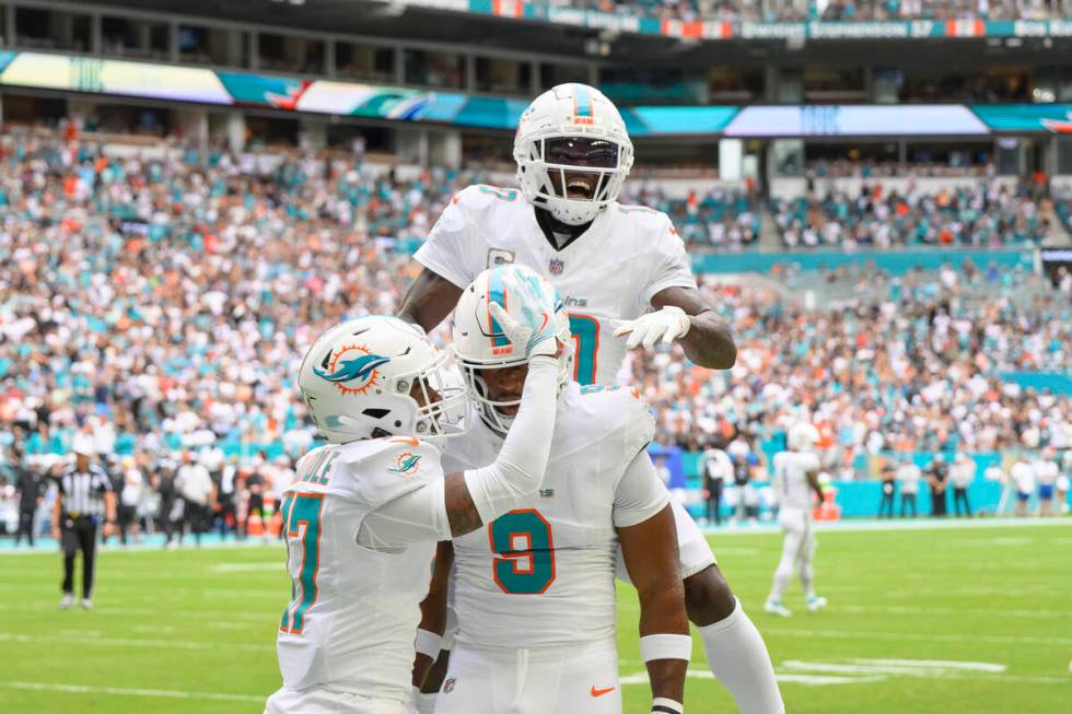 Miami Dolphins wide receiver Tyreek Hill (10) jumps on top of tight end Jonnu Smith (9) as Hill ...