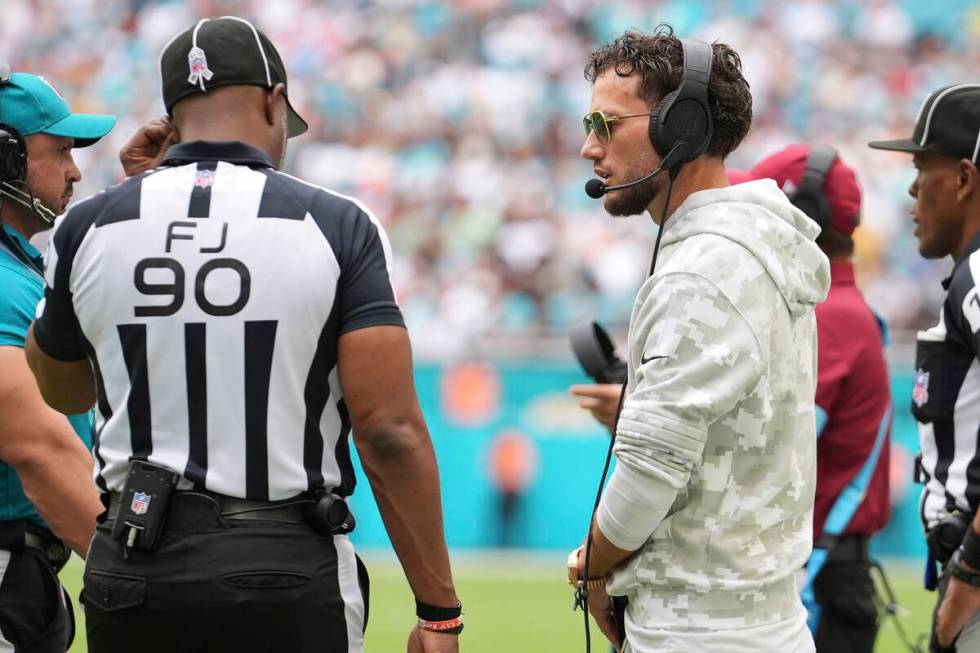 Miami Dolphins head coach Mike McDaniel talks to side judge Anthony Flemming (90) during the fi ...