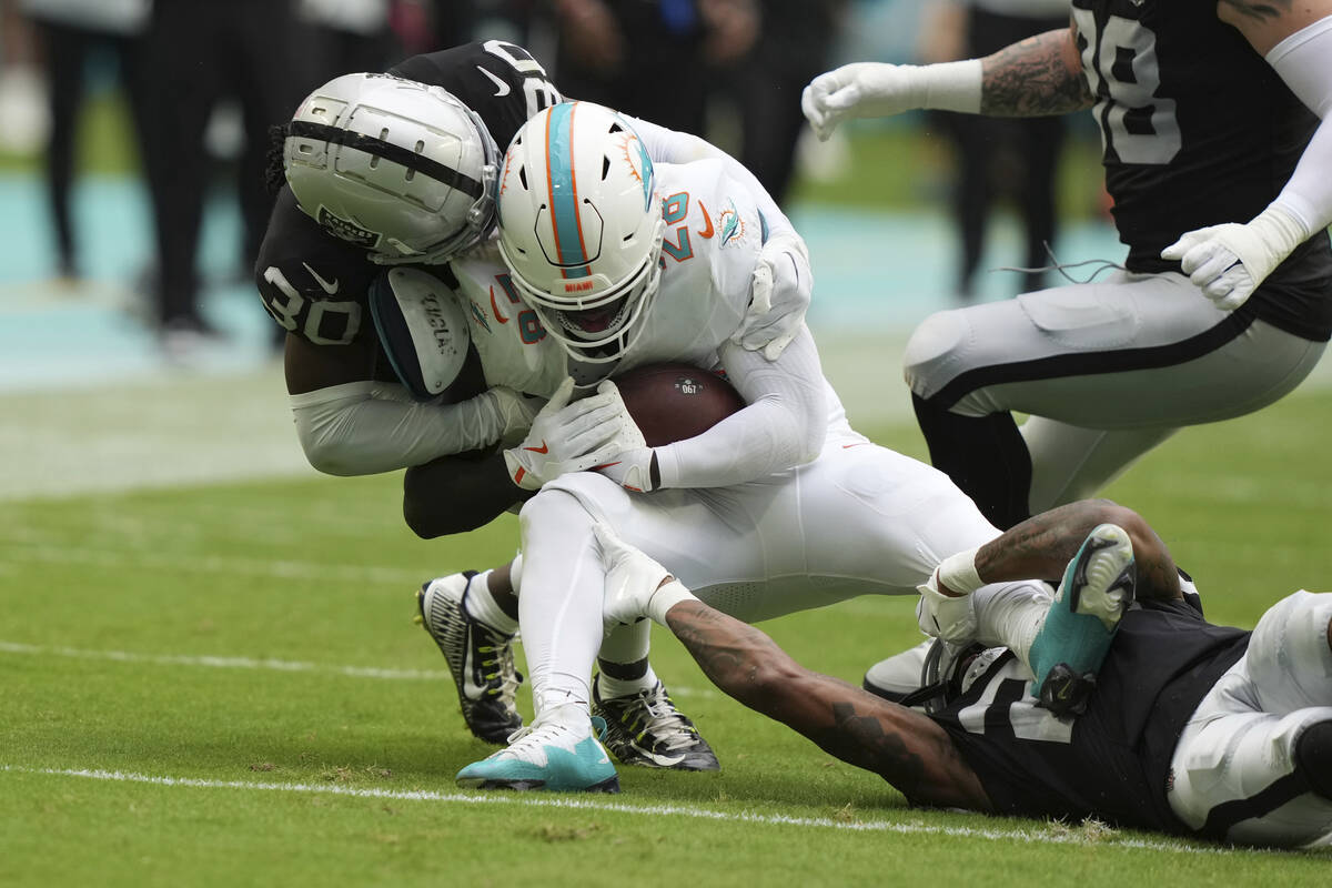 Las Vegas Raiders cornerback Darnay Holmes (30) tackles Miami Dolphins running back De'Von Acha ...