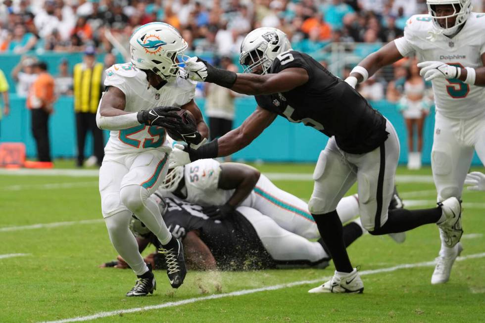 Las Vegas Raiders linebacker Divine Deablo (5) grabs Miami Dolphins running back Jaylen Wright' ...