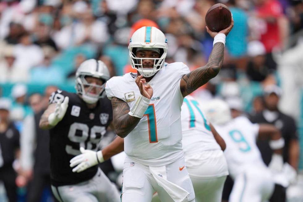 Miami Dolphins quarterback Tua Tagovailoa (1) aims a pass during the first half of an NFL footb ...