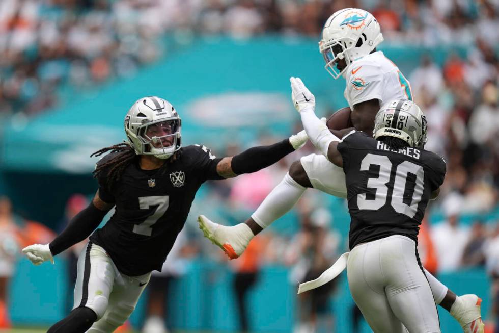 Miami Dolphins wide receiver Tyreek Hill (10) catches a pass in between Las Vegas Raiders safet ...