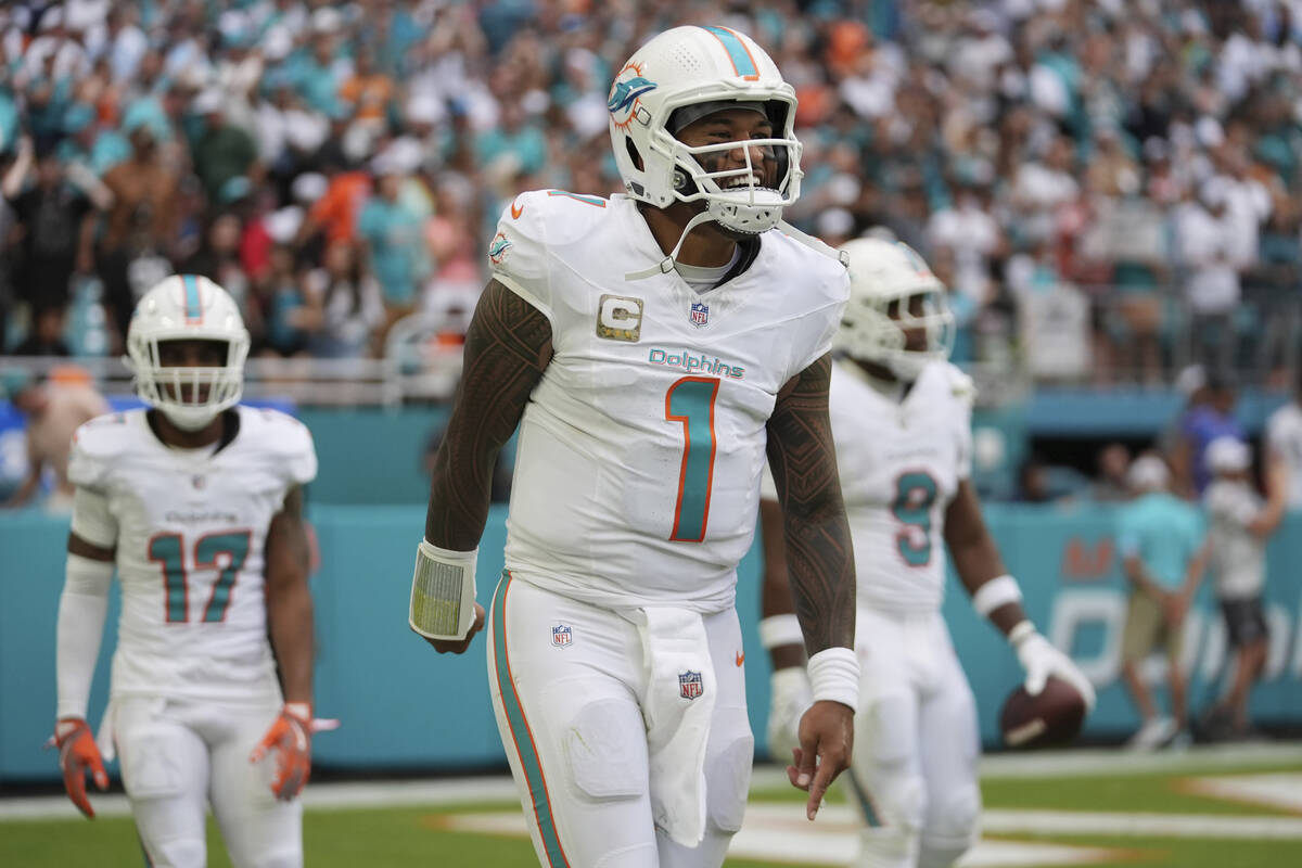 Miami Dolphins quarterback Tua Tagovailoa (1) celebrates a touchdown pass to Miami tight end Jo ...