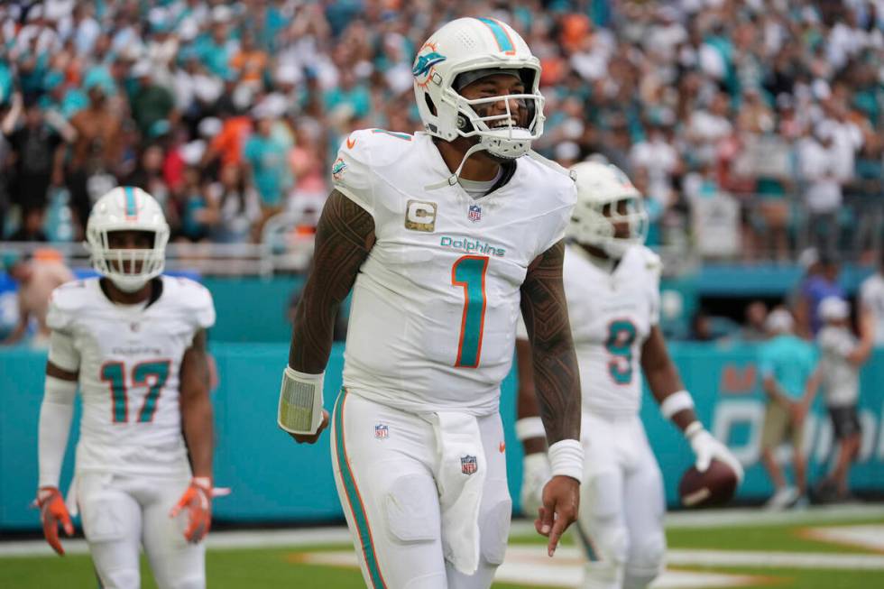 Miami Dolphins quarterback Tua Tagovailoa (1) celebrates a touchdown pass to Miami tight end Jo ...