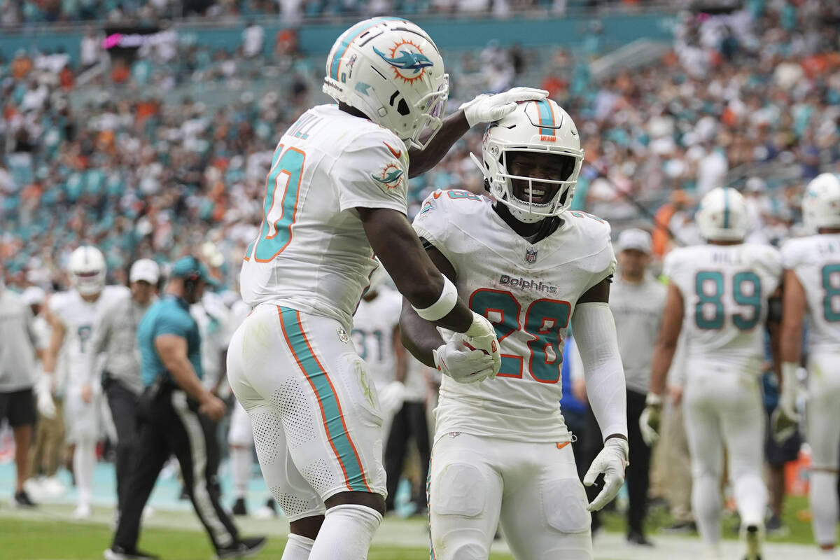 Miami Dolphins running back De'Von Achane (28) celebrates his touchdown with Miami wide receive ...