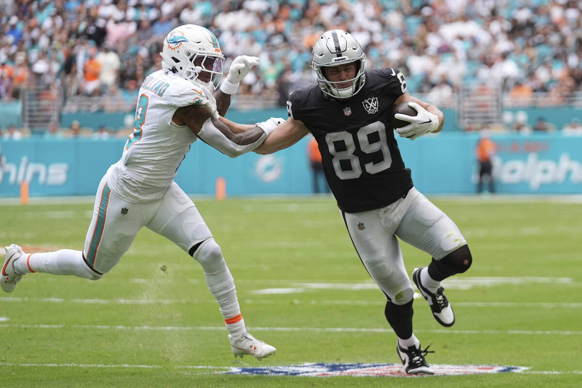 Miami Dolphins safety Jevon Holland (8) grabs Las Vegas Raiders tight end Brock Bowers (89) dur ...