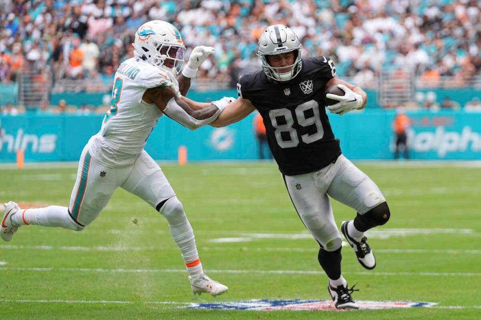 Miami Dolphins safety Jevon Holland (8) grabs Las Vegas Raiders tight end Brock Bowers (89) dur ...