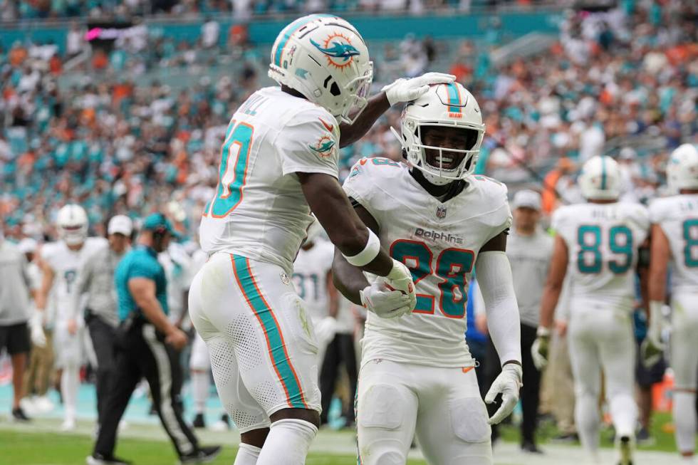 Miami Dolphins running back De'Von Achane (28) celebrates his touchdown with Miami wide receive ...