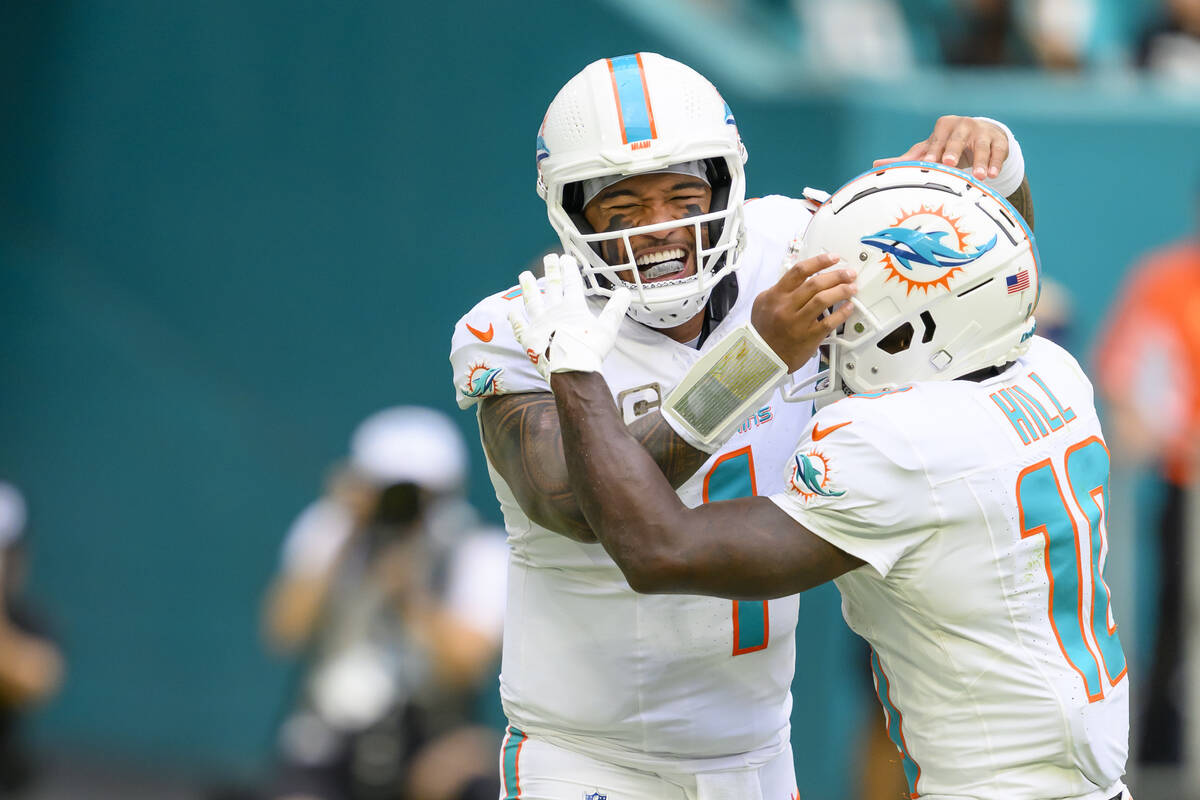 Miami Dolphins quarterback Tua Tagovailoa (1) and wide receiver Tyreek Hill (10) celebrate runn ...