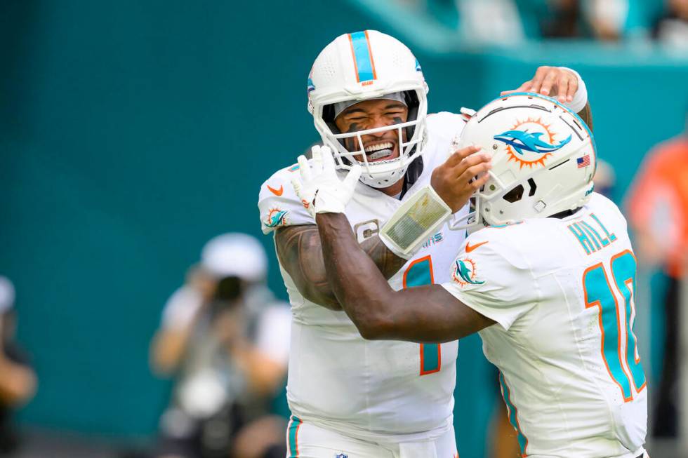 Miami Dolphins quarterback Tua Tagovailoa (1) and wide receiver Tyreek Hill (10) celebrate runn ...