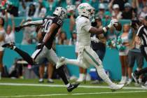 Miami Dolphins tight end Jonnu Smith (9) scores a touchdown as Las Vegas Raiders safety Isaiah ...