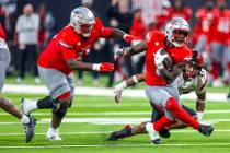 UNLV running back Greg Burrell (5) puts a move on San Diego State Aztecs edge Trey White (47) ...