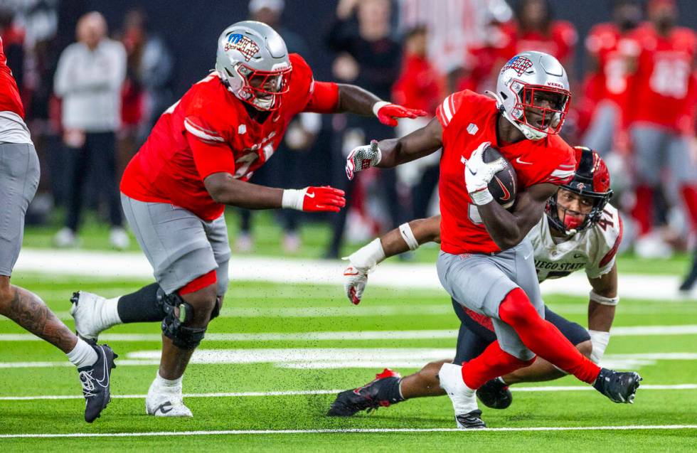 UNLV running back Greg Burrell (5) puts a move on San Diego State Aztecs edge Trey White (47) ...