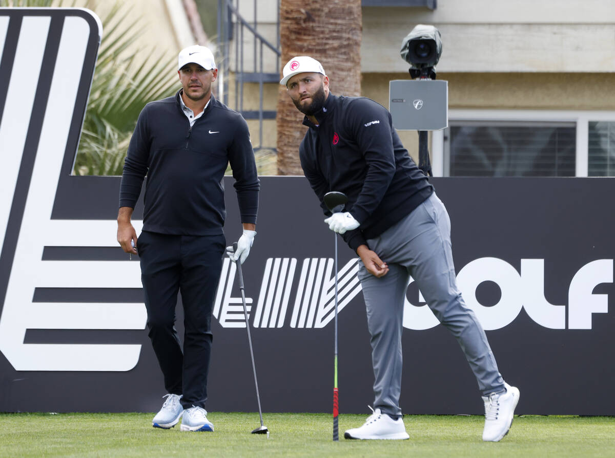 Jon Rahm, right, of team Legion XIII watches his tee drive as Brooks Koepka of team Smash GC lo ...