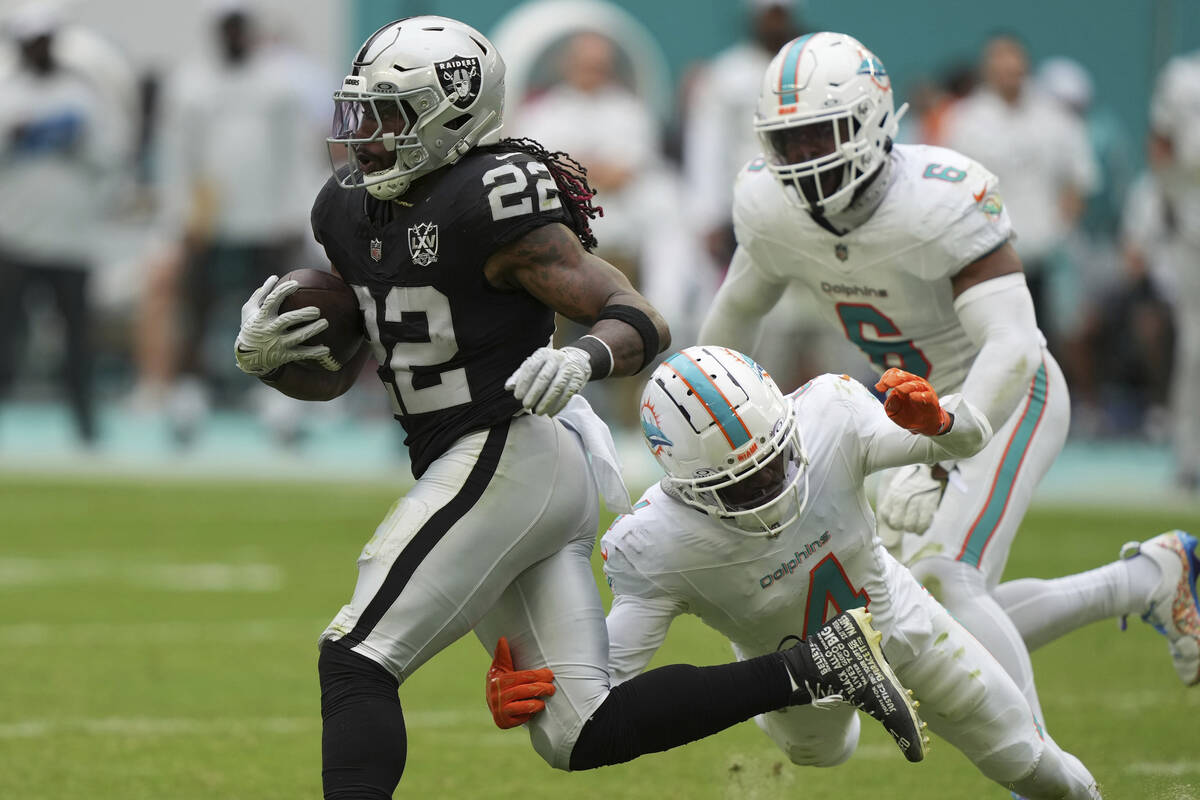 Miami Dolphins cornerback Kader Kohou (4) grabs Las Vegas Raiders running back Alexander Mattis ...