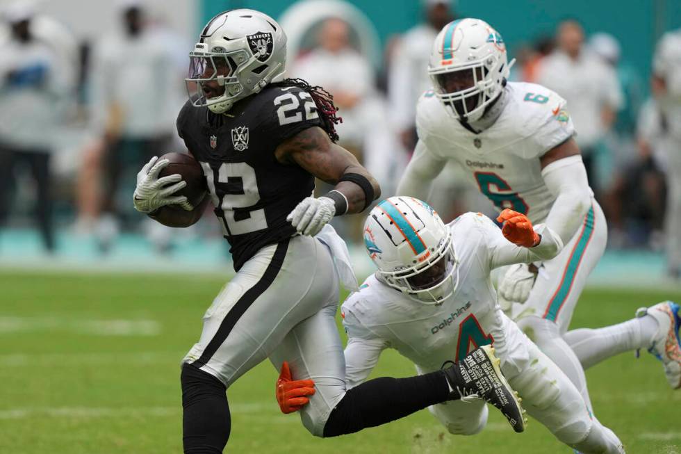 Miami Dolphins cornerback Kader Kohou (4) grabs Las Vegas Raiders running back Alexander Mattis ...