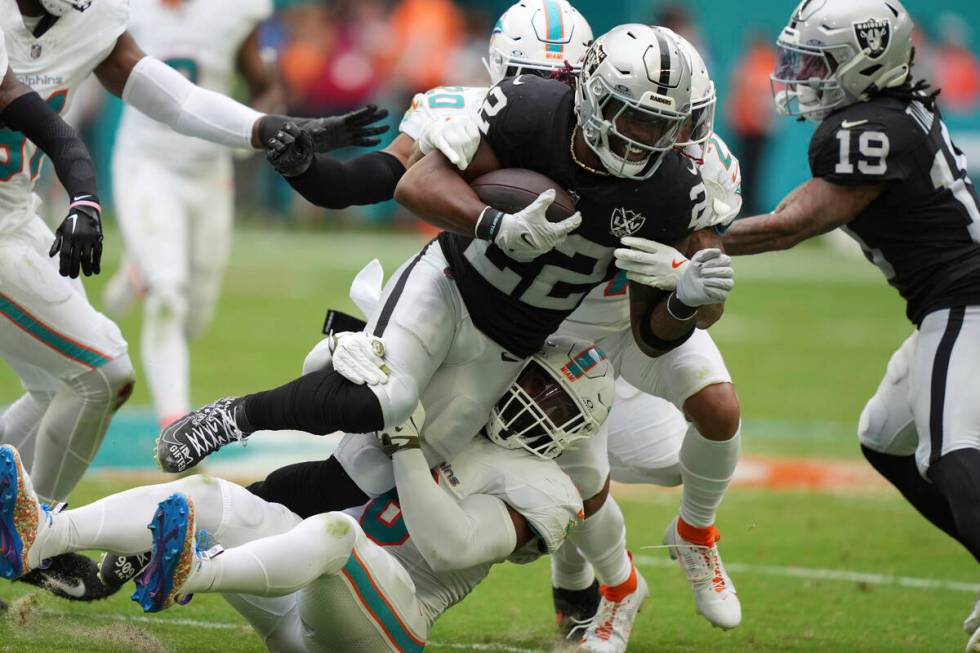 Las Vegas Raiders running back Alexander Mattison (22) is tackled by Miami Dolphins linebacker ...