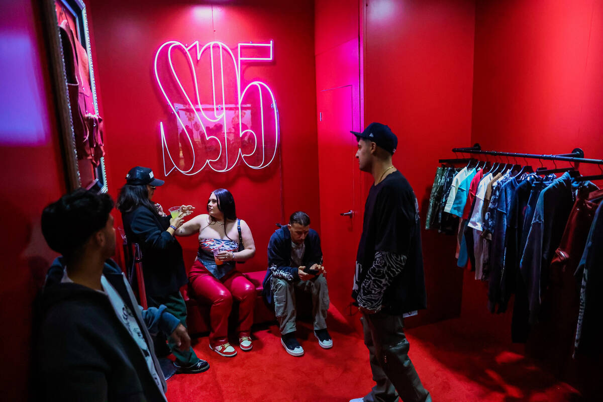 Attendees sit inside a clothing booth to pass time during ComplexCon at the Las Vegas Conventio ...