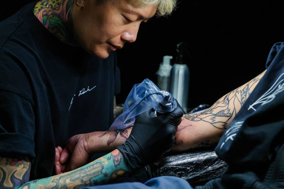 Joshua Lin, a popular tattoo artist, tattoos Eric Lai during ComplexCon at the Las Vegas Conven ...