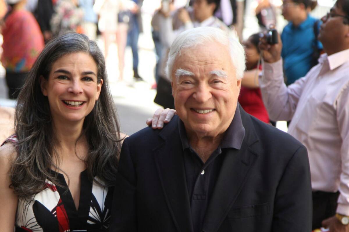 Arthur Frommer, 83, and his daughter, Pauline Frommer, 46, pose among tourists in the Wall Stre ...