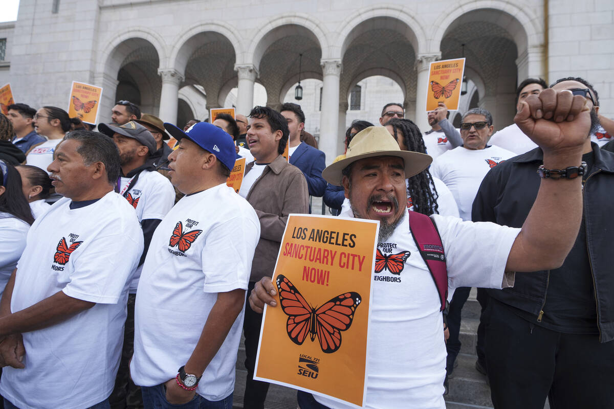 Activist Alejandro Mendez, right, joins members with immigration advocacy groups to demand the ...