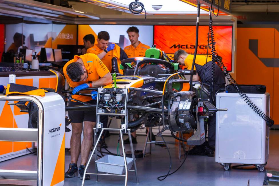 Technicians work on the car of McLaren driver Lando Norris in his garage at the Formula 1 Pit B ...