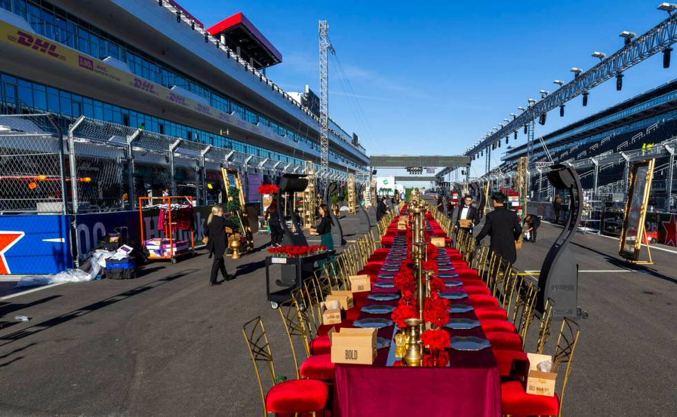 Servers and other contractors continue to set of tables for a pre-race dining experience on the ...