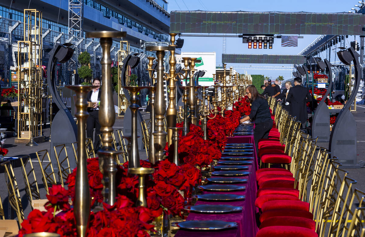 Servers and other contractors continue to set of tables for a pre-race dining experience on the ...