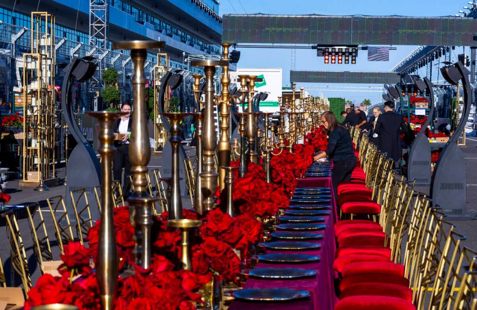 Servers and other contractors continue to set of tables for a pre-race dining experience on the ...