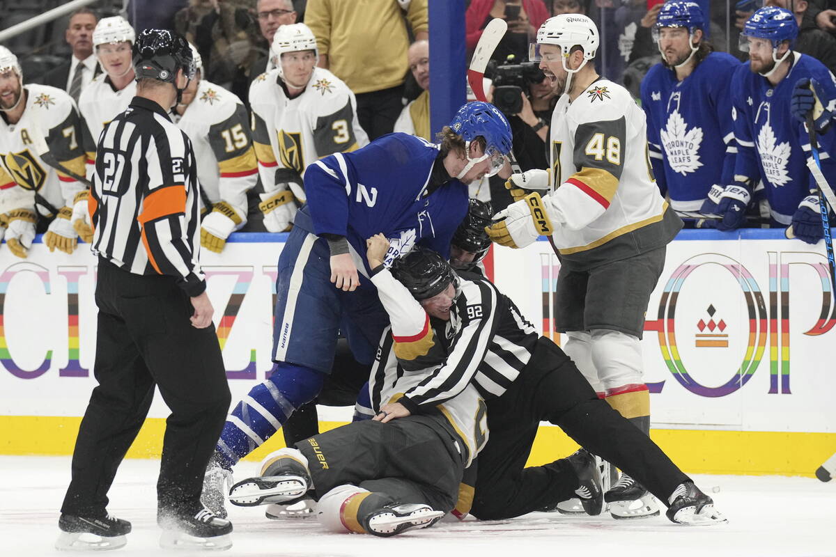 A referee intervenes as Toronto Maple Leafs Simon Benoit (2) fights with Vegas Golden Knights Z ...