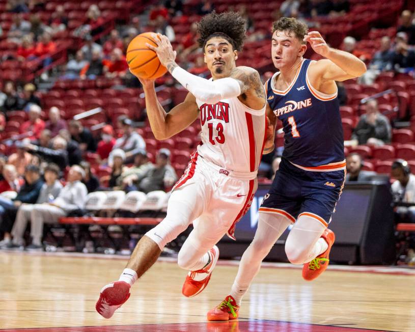 UNLV guard Brooklyn Hicks (13) attempts to run past Pepperdine Waves guard David Mager (1) duri ...