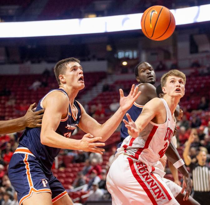 Pepperdine Waves forward Dovydas Butka, left, and UNLV guard Julian Rishwain, right, compete fo ...