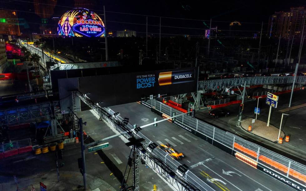 A race car navigates up the track along Koval Lane during the Formula One opening practice sess ...