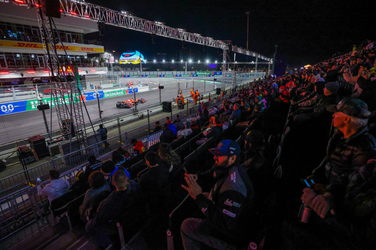 Fans sit in the grandstands as drivers zoom by during Formula 1 opening practice ahead of the F ...