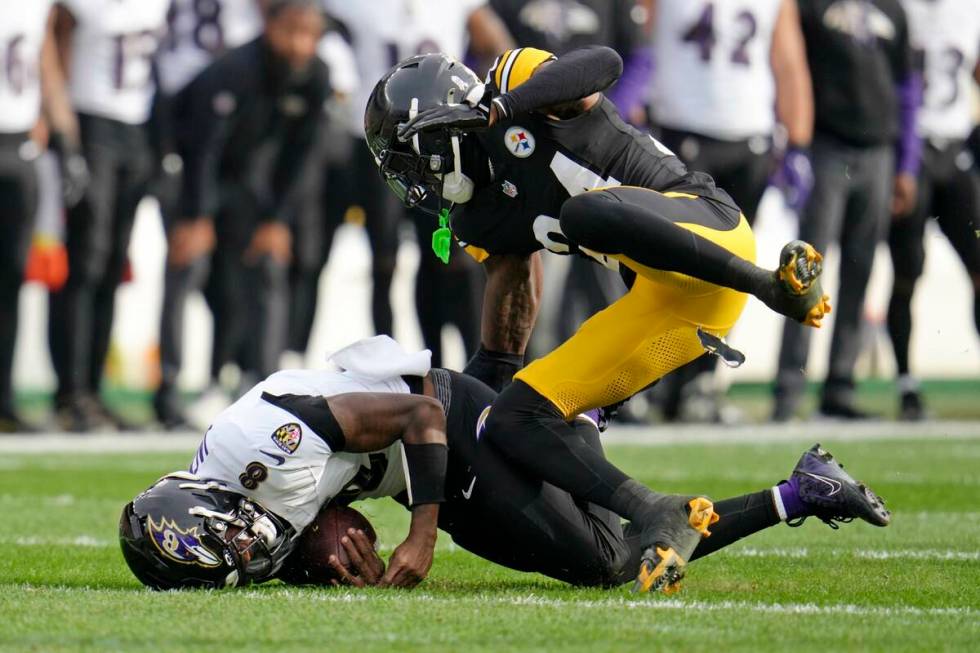 Baltimore Ravens quarterback Lamar Jackson (8) is tackled by Pittsburgh Steelers cornerback Joe ...