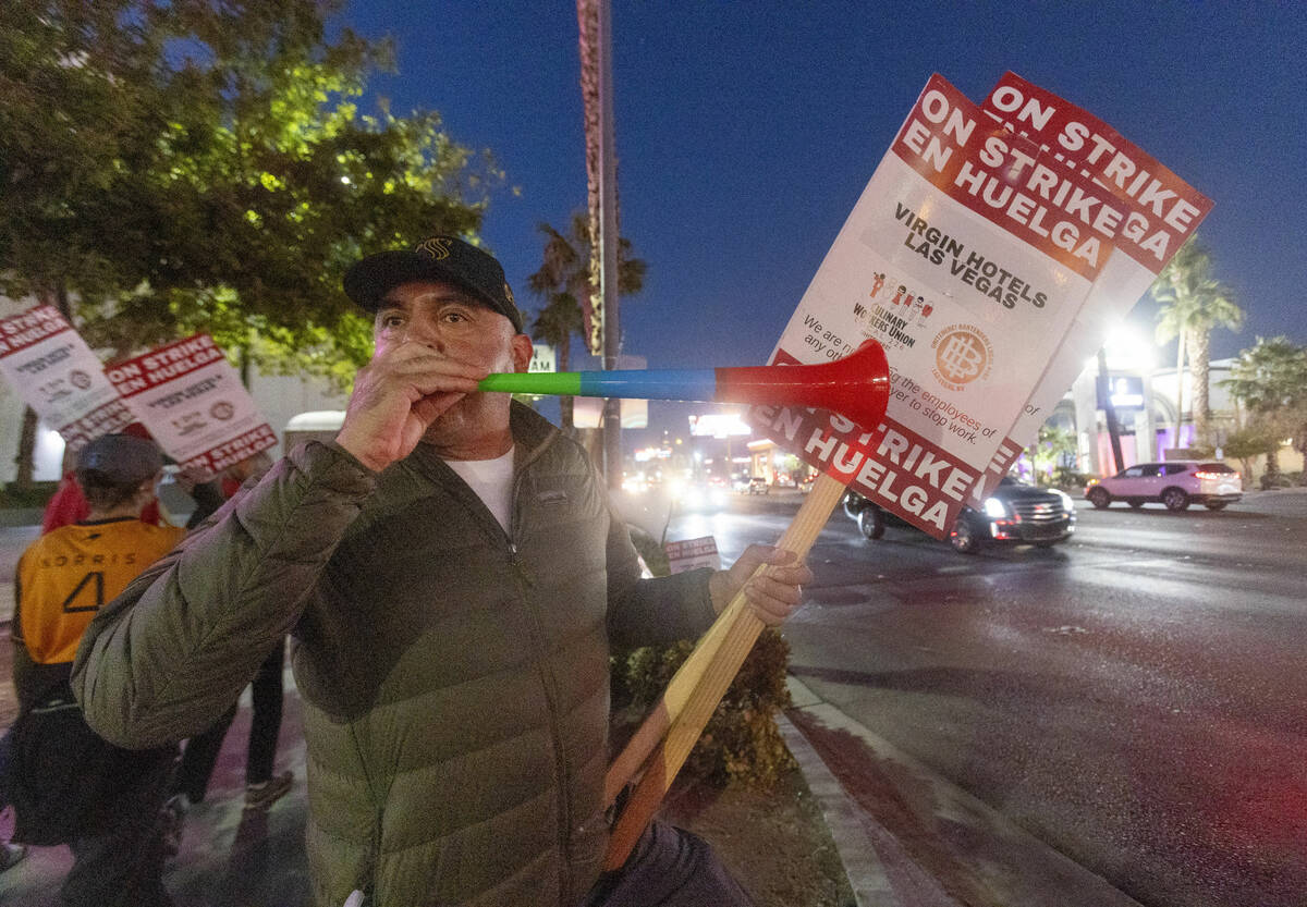 Culinary Workers Union members and Virgin Hotels workers blow horns along a picket line during ...